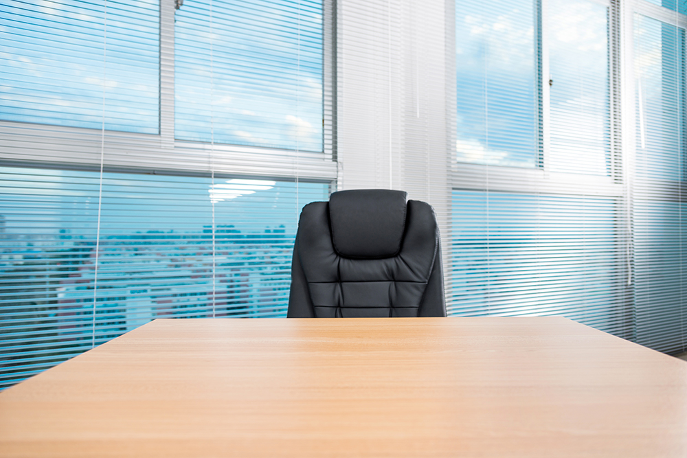 Empty chair at desk in office