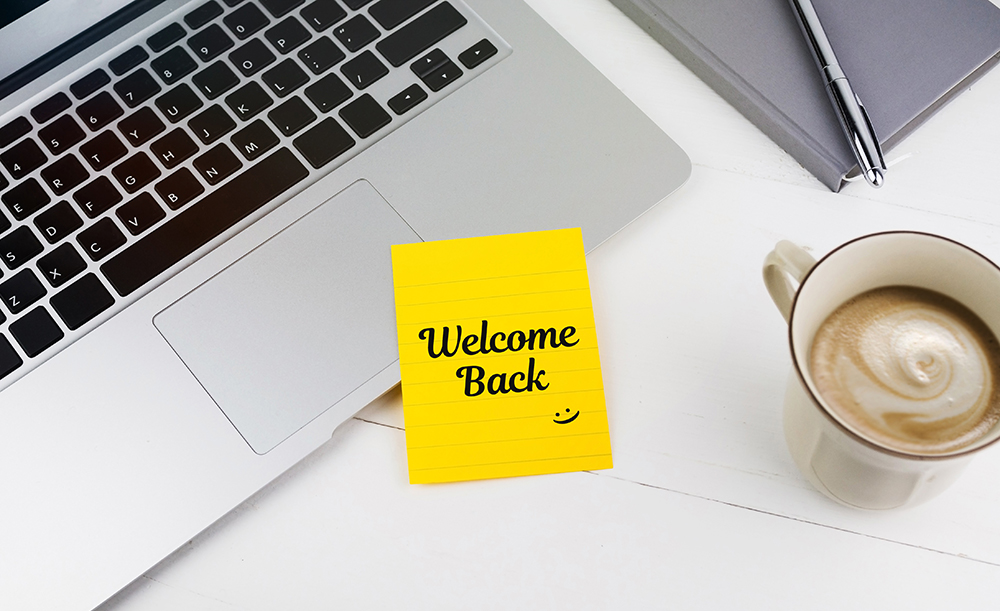 Sticky note on laptop that says welcome back